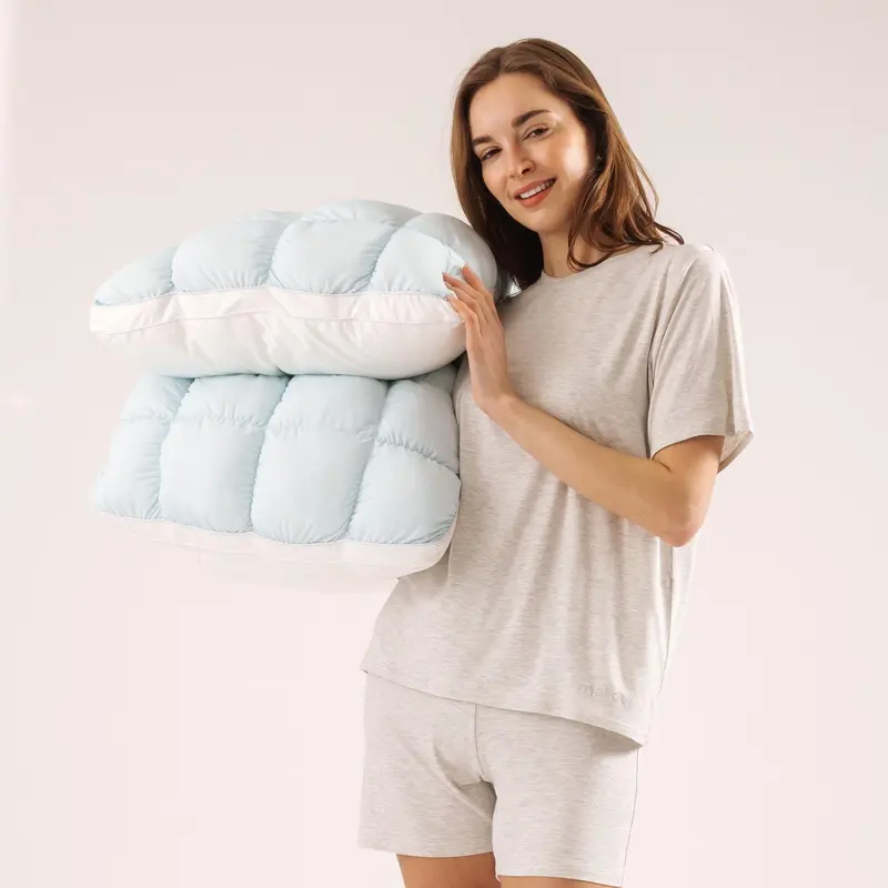Two baby blue CloudSoft pillows held in a lifestyle setting