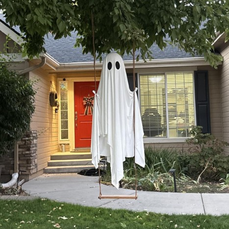 White swing ghost hanging in a front yard during the day